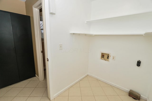 laundry room featuring baseboards, washer hookup, light tile patterned flooring, and laundry area