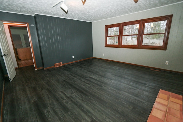 interior space with a healthy amount of sunlight, a ceiling fan, visible vents, dark wood finished floors, and a textured ceiling