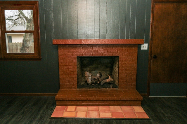details featuring a fireplace, wood finished floors, and baseboards