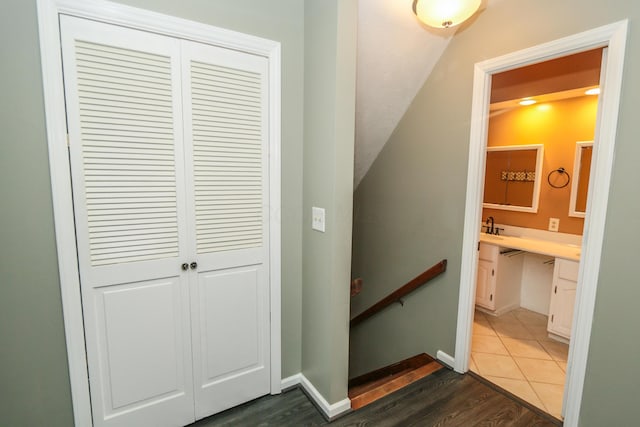 stairway featuring baseboards, lofted ceiling, and wood finished floors