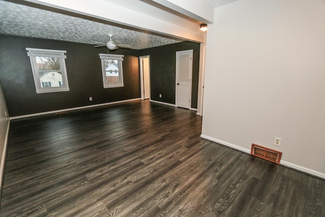 spare room with ceiling fan, wood finished floors, visible vents, and baseboards