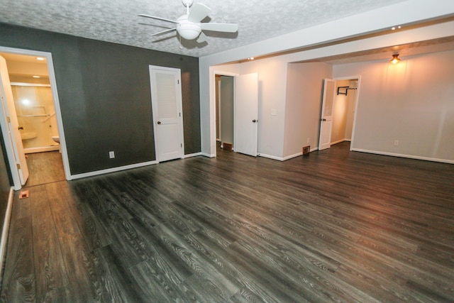 unfurnished bedroom featuring ceiling fan, baseboards, ensuite bathroom, wood finished floors, and a textured ceiling