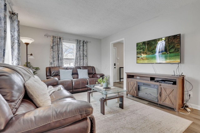 1333 Carolyn Ave, Columbus, OH 43224 - living room featuring light wood-type flooring, baseboards, and a textured ceiling