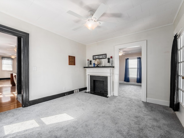 unfurnished living room featuring a fireplace with flush hearth, carpet, and a ceiling fan