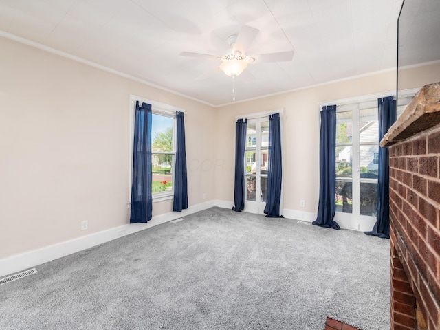 spare room with ceiling fan, crown molding, carpet, and plenty of natural light