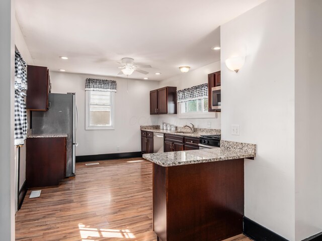 kitchen featuring stainless steel appliances, plenty of natural light, a ceiling fan, and a sink