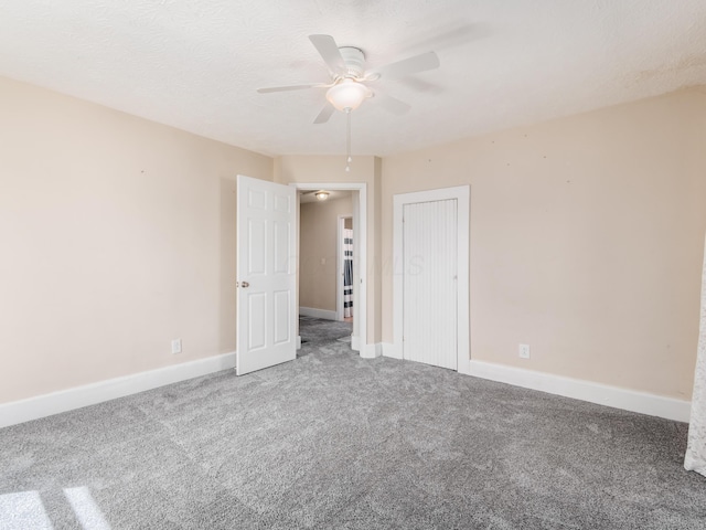 unfurnished bedroom with baseboards, ceiling fan, carpet floors, and a closet