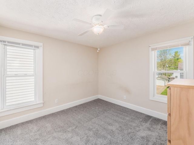 unfurnished room featuring baseboards, a ceiling fan, carpet floors, and a textured ceiling