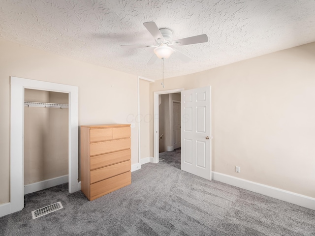 unfurnished bedroom featuring a closet, visible vents, carpet, baseboards, and a textured ceiling