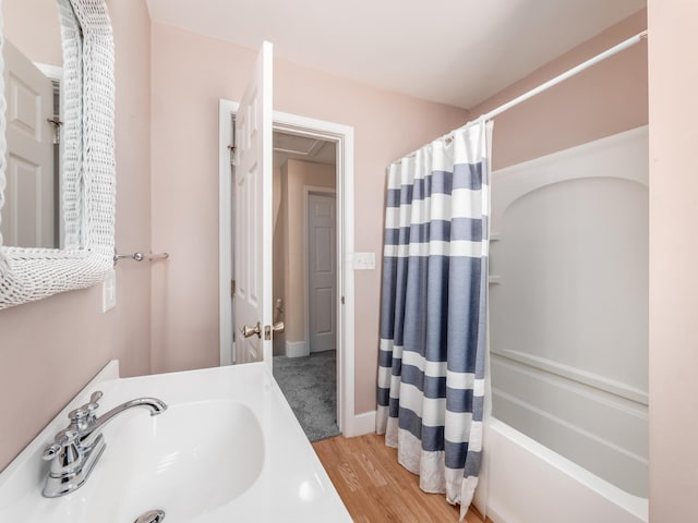 full bathroom featuring shower / bathtub combination with curtain, wood finished floors, and a sink