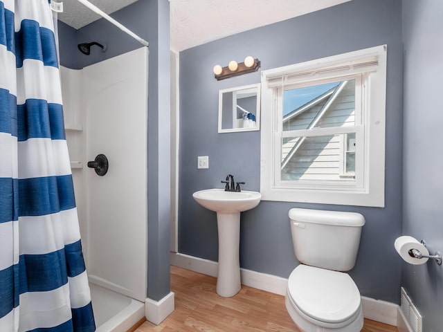 full bath with visible vents, a shower with shower curtain, baseboards, toilet, and wood finished floors