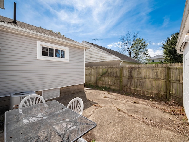 view of patio / terrace with outdoor dining area, a fenced backyard, and central AC unit