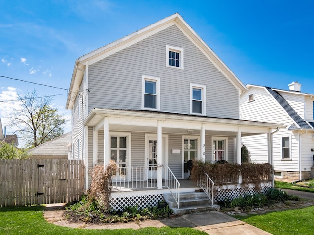 view of front facade featuring covered porch and fence