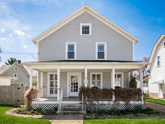 view of front of home with covered porch and fence