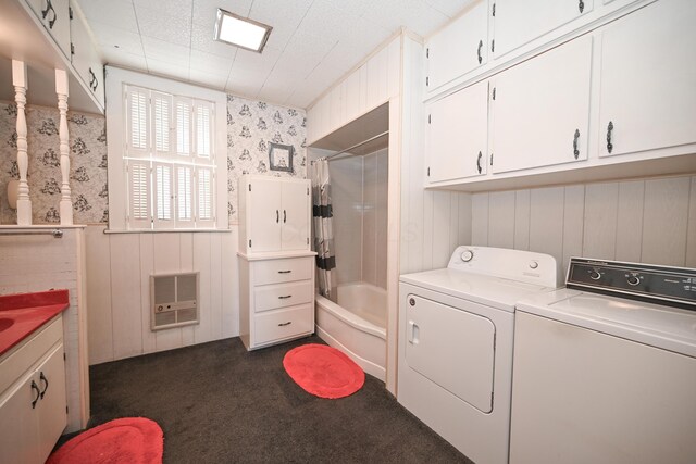 laundry room with a wainscoted wall, heating unit, separate washer and dryer, dark colored carpet, and laundry area
