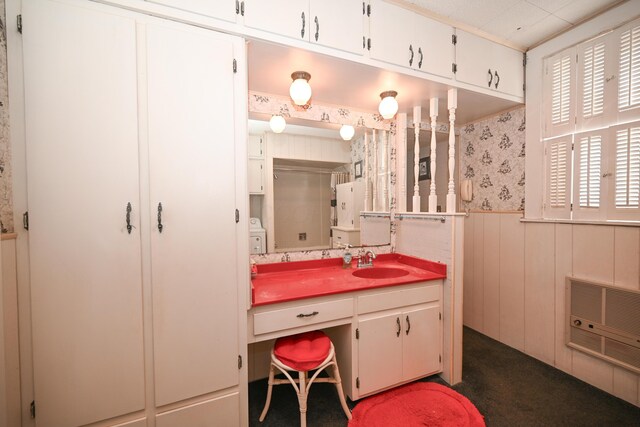 bathroom featuring heating unit, a wainscoted wall, wallpapered walls, and vanity