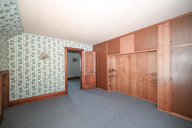 unfurnished bedroom featuring a closet, carpet flooring, and wallpapered walls