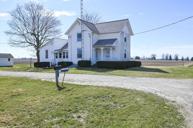 view of front facade with driveway, a front yard, and a shingled roof