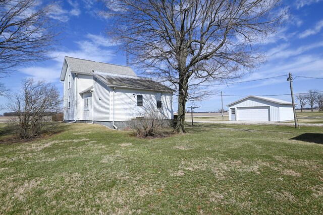 view of home's exterior featuring an outdoor structure, a lawn, and a detached garage