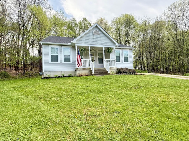view of front of property with roof with shingles, a porch, and a front lawn