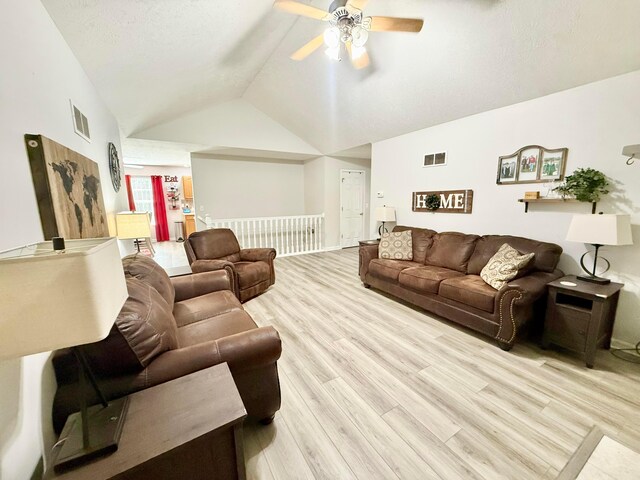 living area featuring a ceiling fan, visible vents, wood finished floors, and lofted ceiling