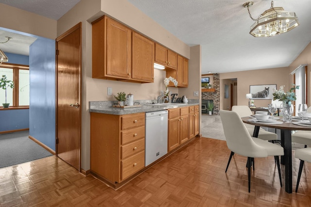 kitchen with an inviting chandelier, a textured ceiling, baseboards, and white dishwasher