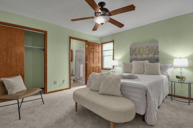 bedroom with a closet, light colored carpet, a ceiling fan, connected bathroom, and baseboards