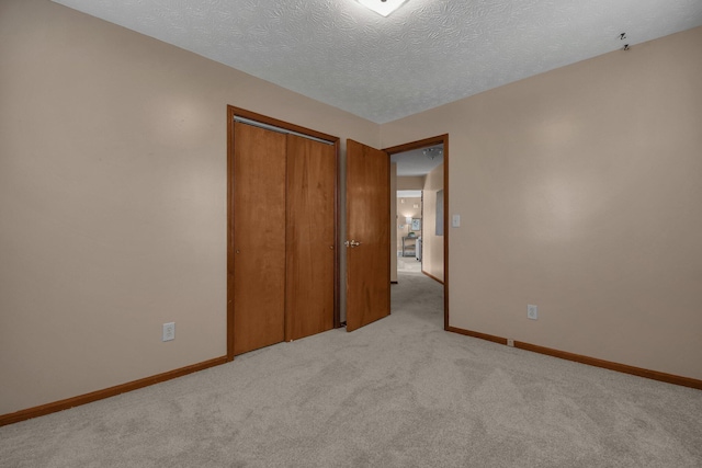 unfurnished bedroom with a closet, light carpet, and baseboards