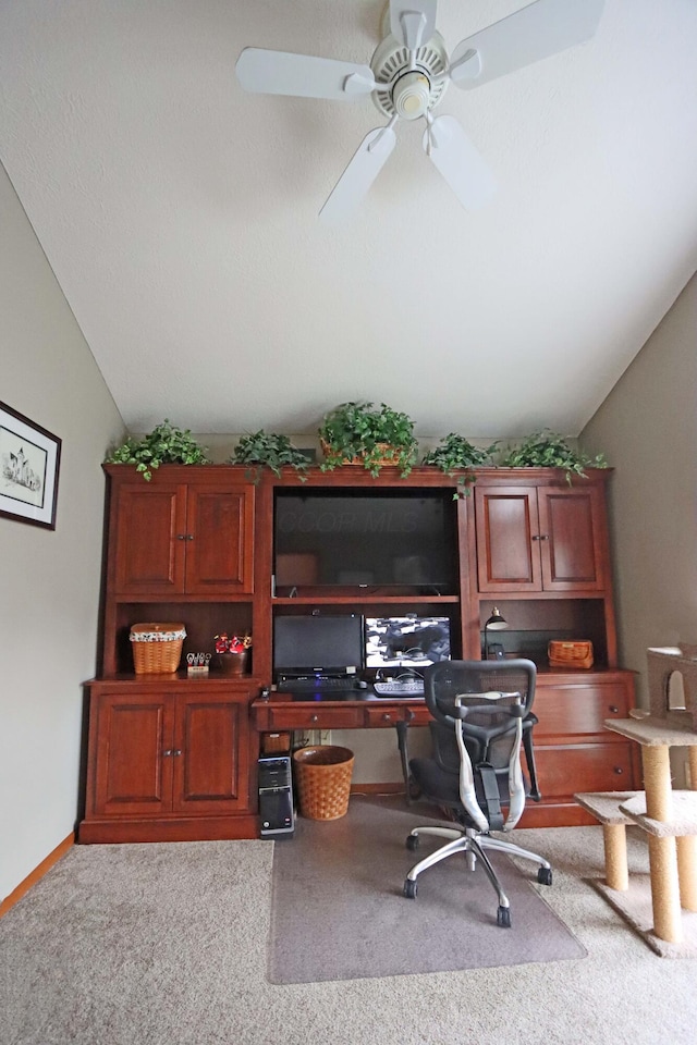 carpeted home office featuring baseboards, lofted ceiling, and ceiling fan