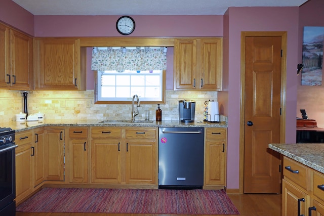 kitchen featuring light stone countertops, light wood finished floors, a sink, dishwasher, and backsplash