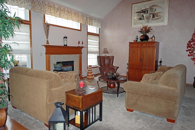 carpeted living area with lofted ceiling, a fireplace, and a healthy amount of sunlight
