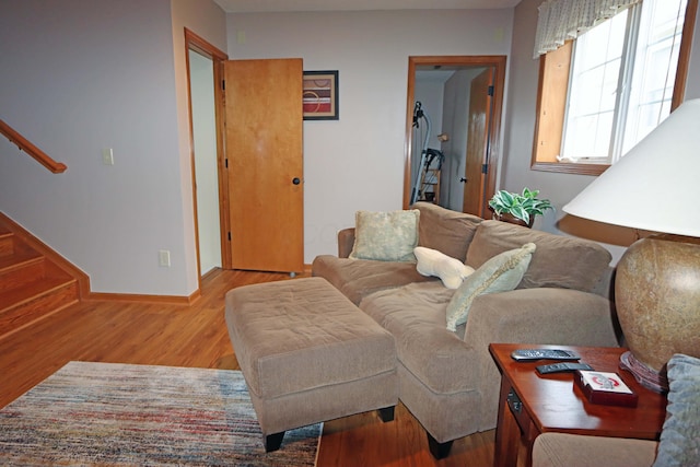 living area featuring stairs, wood finished floors, and baseboards