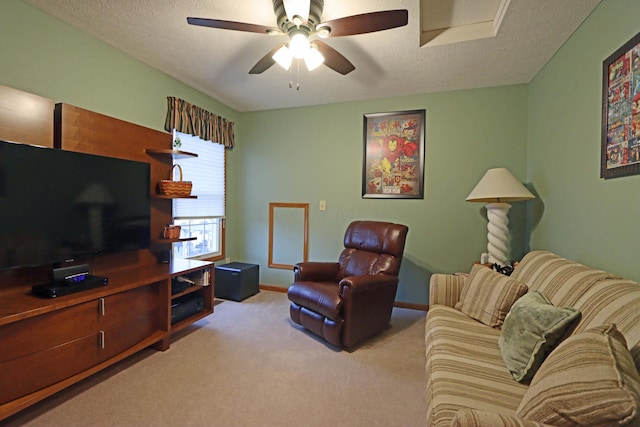 carpeted living room featuring baseboards, a textured ceiling, and ceiling fan