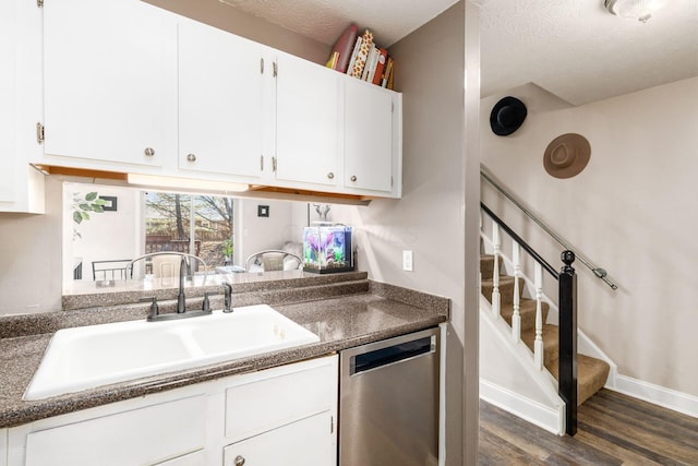 500 Foxtrail Cir E, Westerville, OH 43081 - kitchen with dark countertops, a sink, dark wood finished floors, white cabinetry, and stainless steel dishwasher