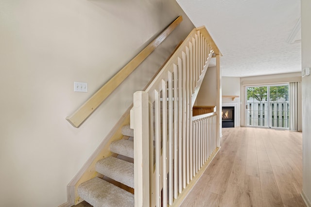 692 Parkbluff Way, Lewis Center, OH 43035 - staircase with wood finished floors and a glass covered fireplace