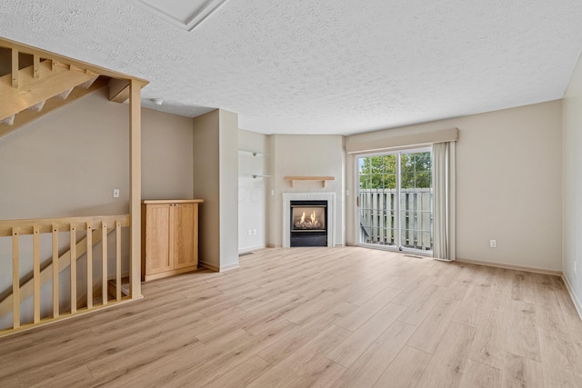 692 Parkbluff Way, Lewis Center, OH 43035 - unfurnished living room featuring light wood finished floors, a textured ceiling, and a fireplace