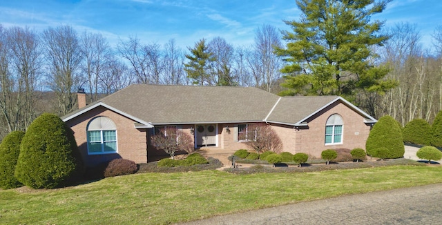 ranch-style house featuring a chimney and a front lawn