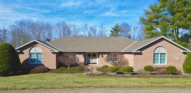 single story home featuring a front lawn, brick siding, and a chimney