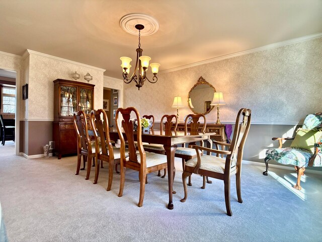 dining area featuring baseboards, wallpapered walls, an inviting chandelier, ornamental molding, and light carpet