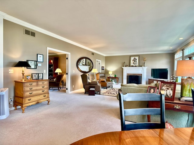 living area featuring baseboards, visible vents, carpet floors, a fireplace, and ornamental molding