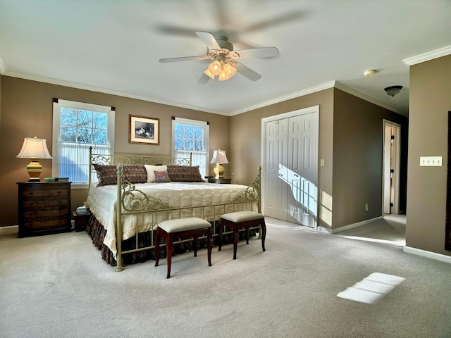 bedroom with crown molding, ceiling fan, carpet, baseboards, and a closet