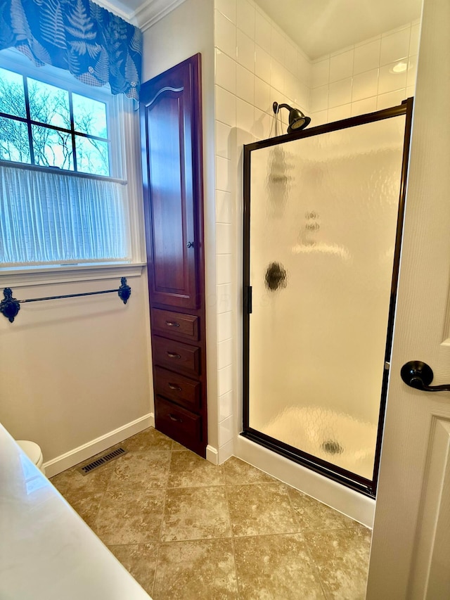 bathroom with a shower stall, baseboards, and visible vents