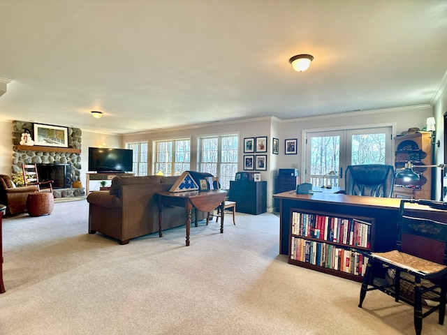 living area featuring plenty of natural light, a fireplace, crown molding, and carpet