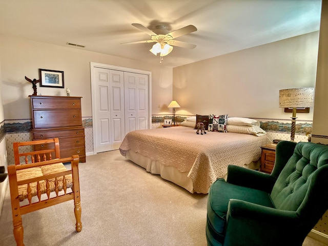 bedroom with visible vents, carpet floors, a closet, and a ceiling fan