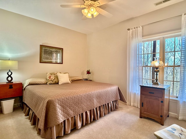 bedroom with visible vents, multiple windows, light colored carpet, and a ceiling fan