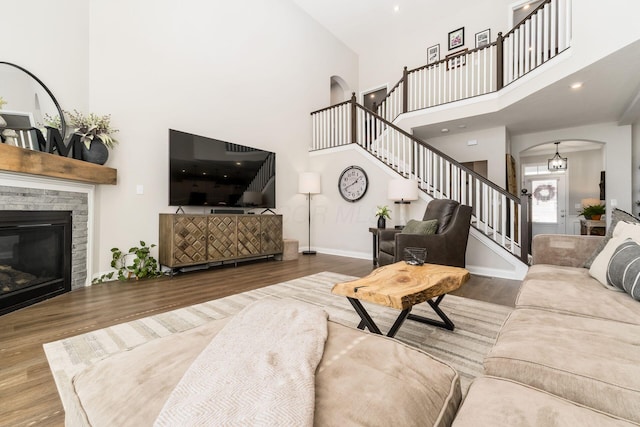 205 Partridge Ct, Pickerington, OH 43147 - living area featuring wood finished floors, arched walkways, a high ceiling, baseboards, and stairs