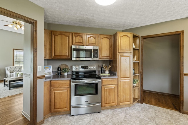 kitchen with brown cabinetry, open shelves, light wood finished floors, and stainless steel appliances