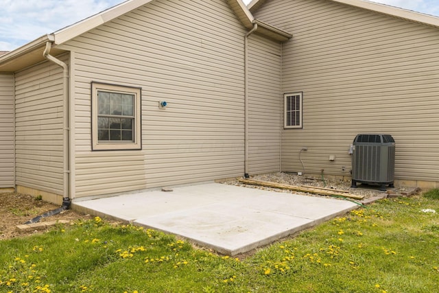 back of house with a lawn, a patio, and central AC