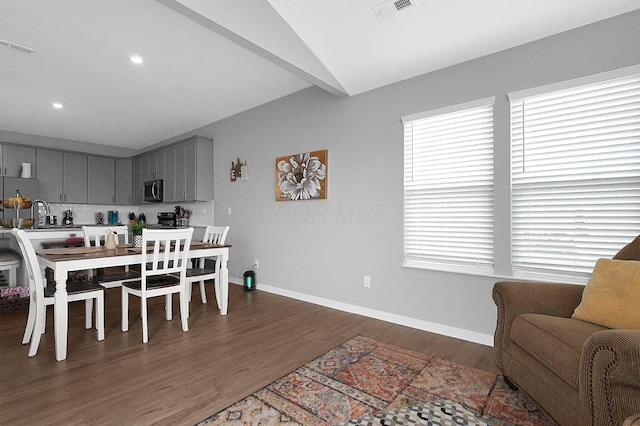 dining space featuring dark wood finished floors, visible vents, and baseboards