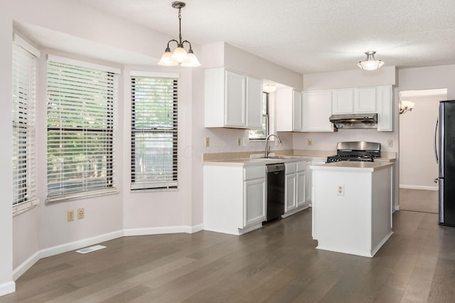kitchen with an inviting chandelier, under cabinet range hood, a sink, and gas stove